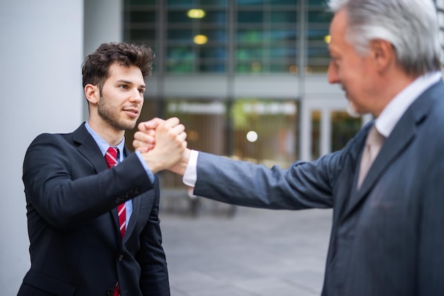 Successful business people joining hands with another