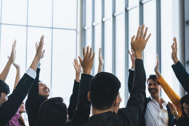 Successful business people raised their hands up for voting showing their approval volunteering in the office seminar with happiness Smile managers put their hands up in the air Intellectual