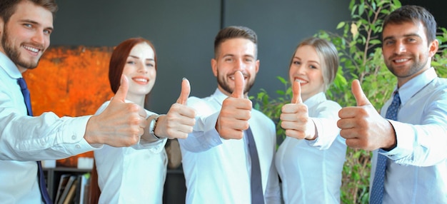 Photo successful business people with thumbs up and smiling