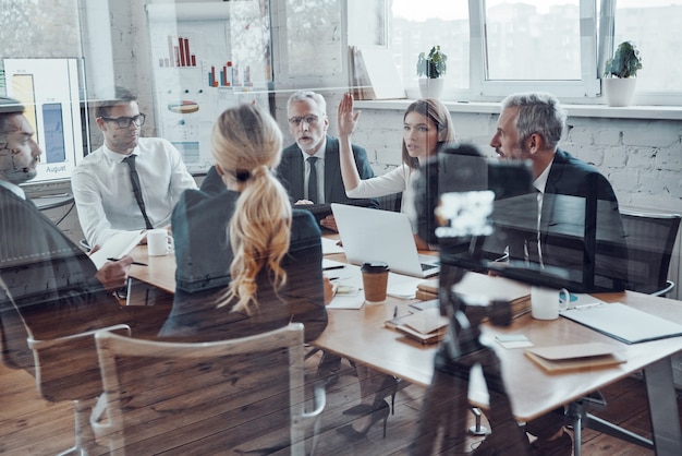 Successful business team discussing strategy while filming staff meeting in the board room