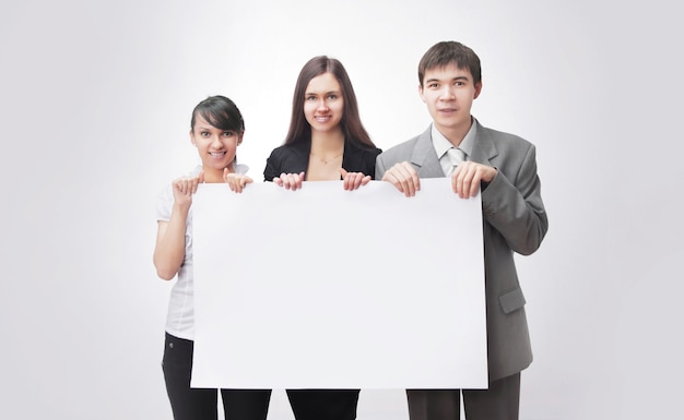 Successful business team holding a blank banner. isolated on white