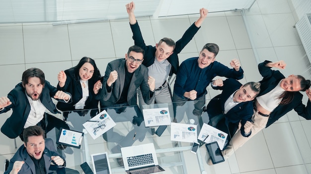 Successful business team sitting at a desk and looking at the camera