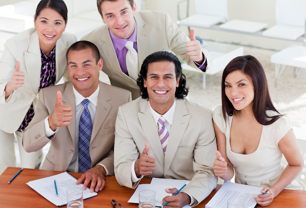 Successful business team with thumbs up 