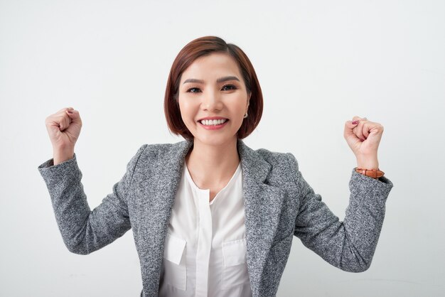 Successful business woman celebrating with arms up on white