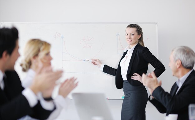 현대적인 밝은 사무실에서 직원들과 함께 서 있는 성공적인 비즈니스 여성