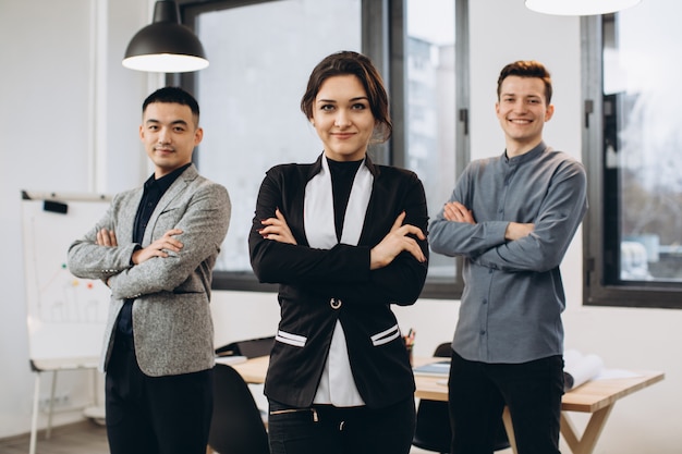 Successful business woman standing with her staff in at office