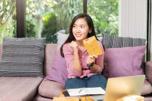 Successful business woman with online sales and Parcel shipping in her home office.