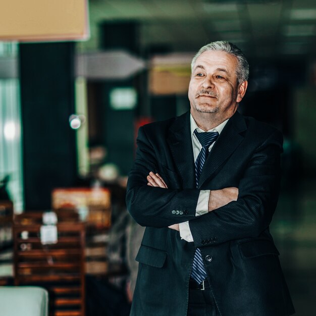 Successful businessman in a business suit on background of modern office