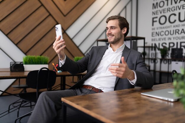 Successful businessman in a business suit communicates via smartphone video link while sitting at a