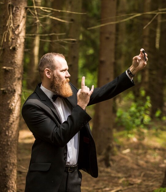 Successful businessman in a business suit taking a selfie in the park