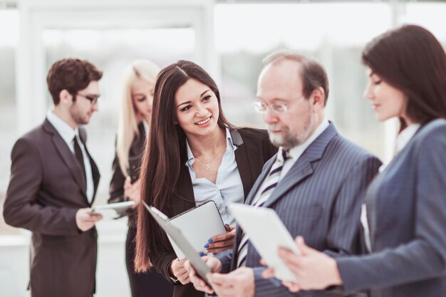 Successful businessman and business team discussing business documents standing in the lobby of the