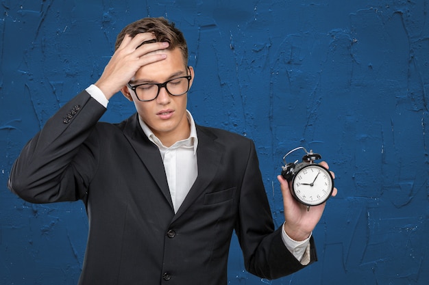 Successful businessman in formal wear pointing at clock