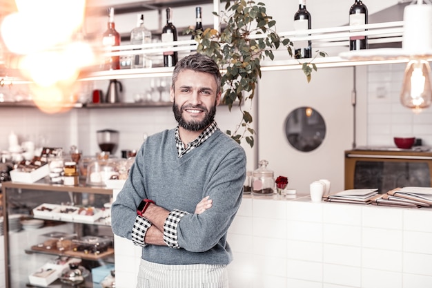 Successful businessman. Handsome delighted man being in a great mood while owning a successful cafe