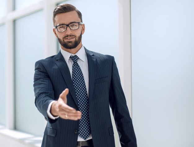 Successful businessman holding out his hand for a handshake photo with copy space