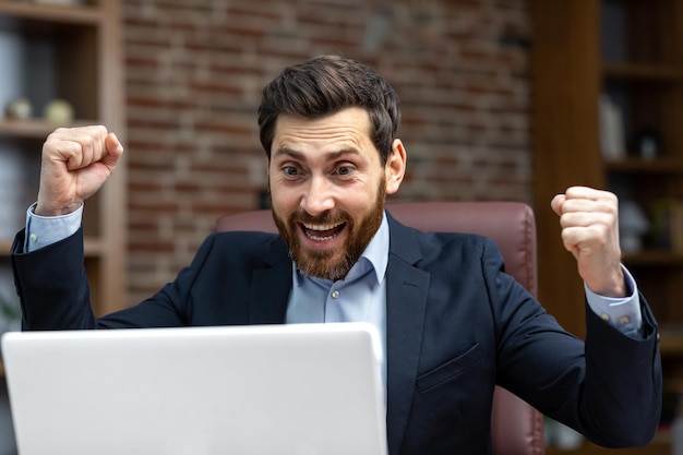 Photo successful businessman in home office celebrating victory and success mature adult male boss