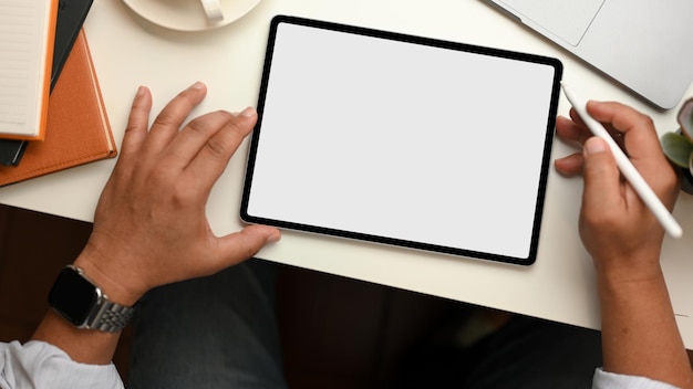 Successful businessman using portable tablet computer at his workspace. top view