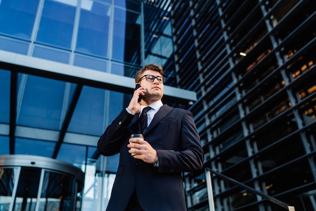 Successful businessman with coffee speaking on phone