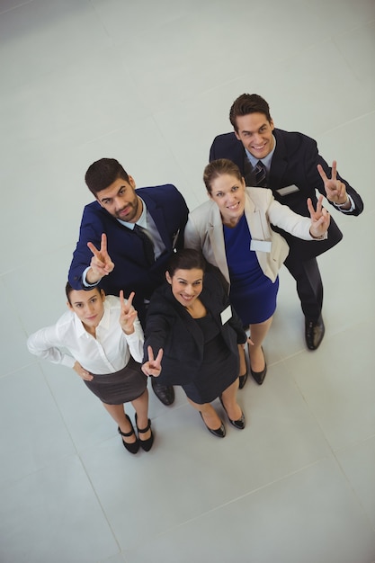 Successful businesspeople showing victory sign