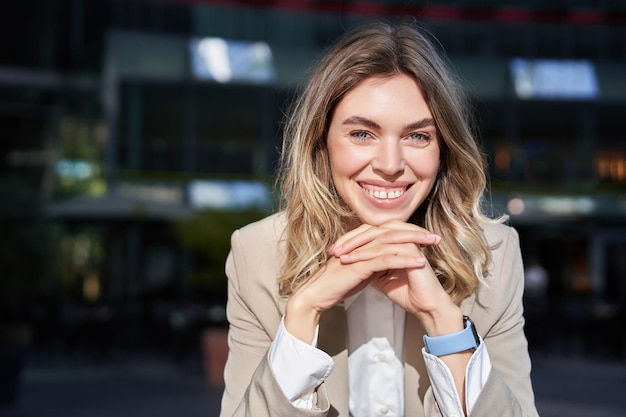 Successful businesswoman smiling looking confident and happy standing in suit on street leans her he