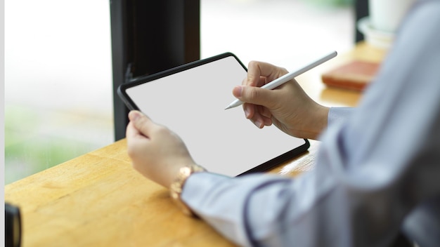 Successful businesswoman using stylus pen to create her presentation on digital tablet computer. tablet blank screen mockup.