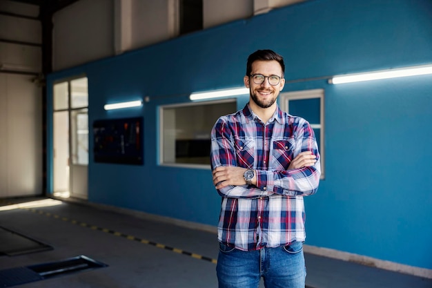 A successful car mechanic shop owner smiling at the camera