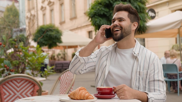 成功した白人男性携帯電話スマートフォン電話ハンサムなビジネスマン朝食コーヒー