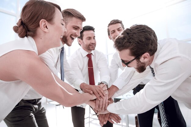 Successful colleagues join their hands together