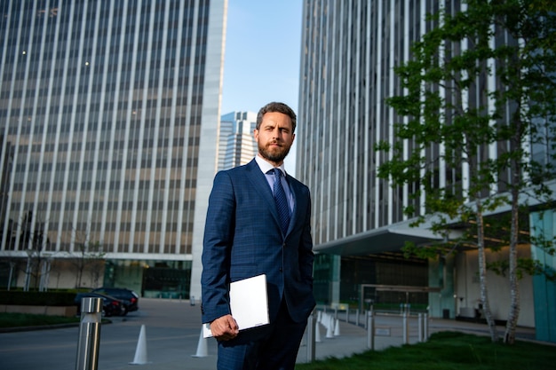 Successful confident businessman among office buildings business man portrait confident director of ...