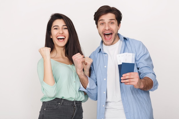 Successful couple showing passports with flying tickets