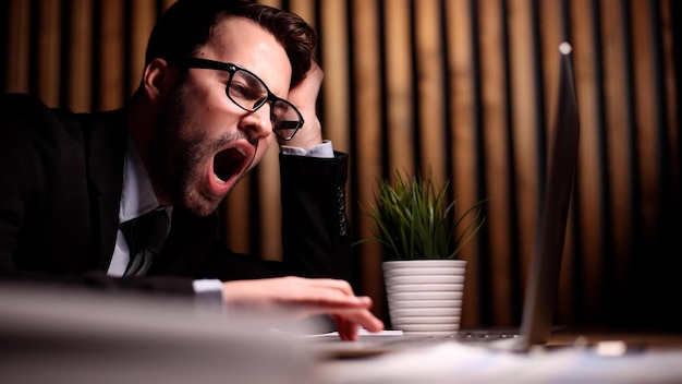 Successful employee stretching and yawning during break in office after work done