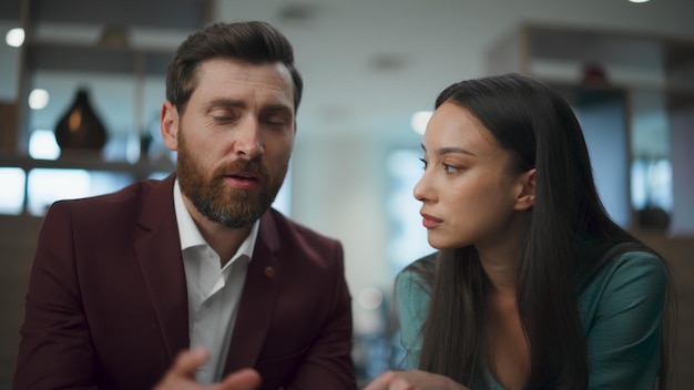 Foto una coppia di imprenditori di successo che parla con un cliente, un uomo dell'ufficio che spiega al portatile.