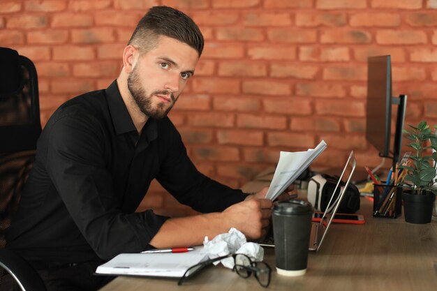 Successful entrepreneur is studying documents with attentive and concentrated look.