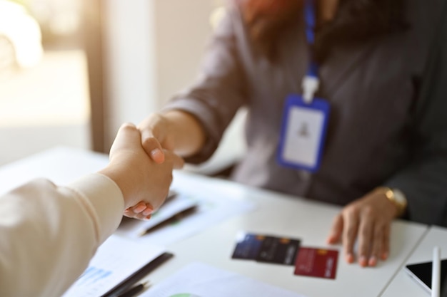 Successful female banker shaking hands with her client after the meeting