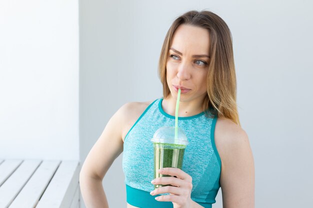 Successful fitness urban woman recommending detox smoothie, close-up