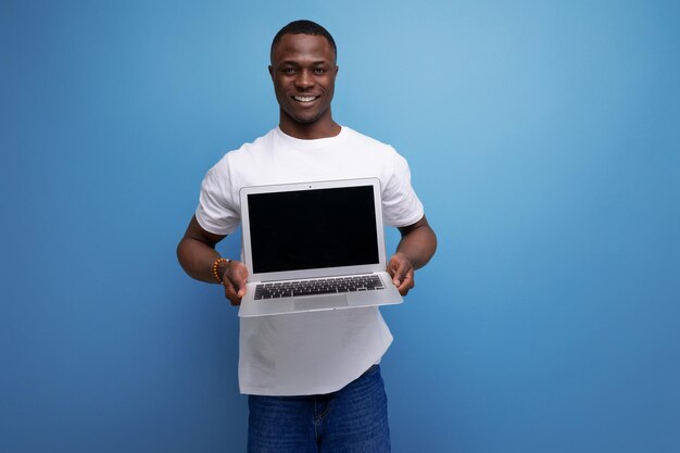 Successful handsome black young american freelance guy in white tshirt with laptop