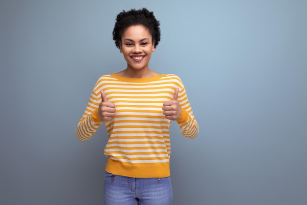 Successful happy brunette latin young woman with ponytail smiling on studio background