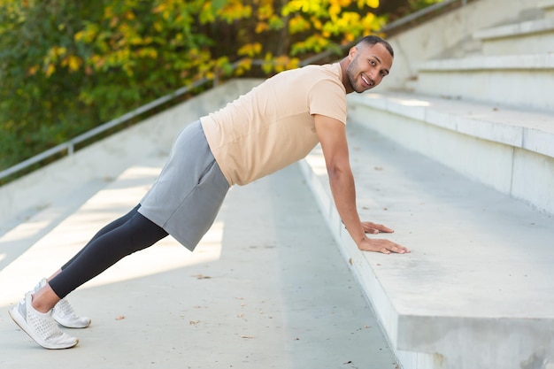 Successful hispanic sportsman doing various physical exercises morning workout at the stadium man