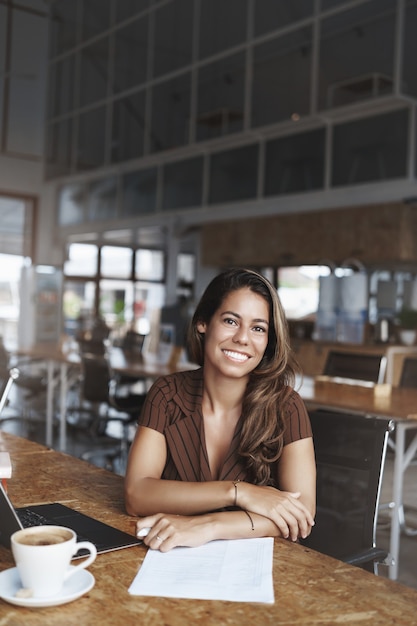 and successful hispanic woman smiling working in cafe