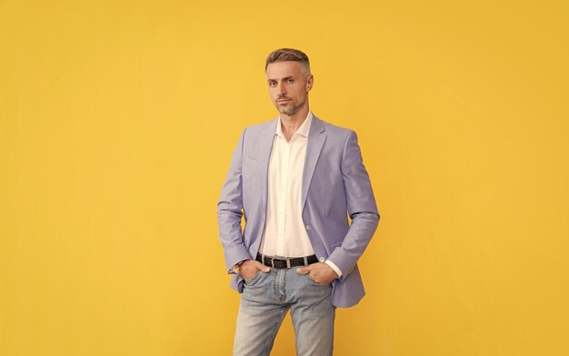 Successful man in businesslike suit manager executive on yellow background