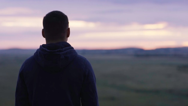 Foto uomo di successo che guarda il cielo al tramonto festeggiando godendo della libertà emozione umana positiva sentimento