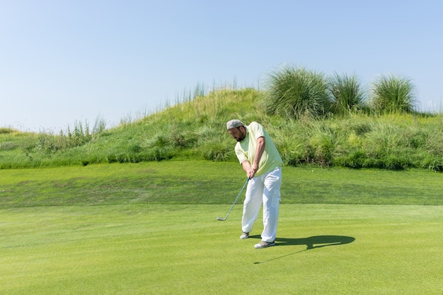 Successful man playing golf at club