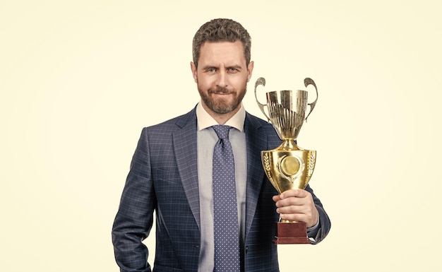 Successful man in suit hold champion cup s business reward isolated on white business success