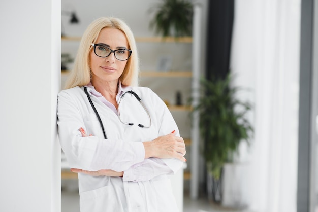 Successful mature caucasian senior female doctor in white coat at hospital