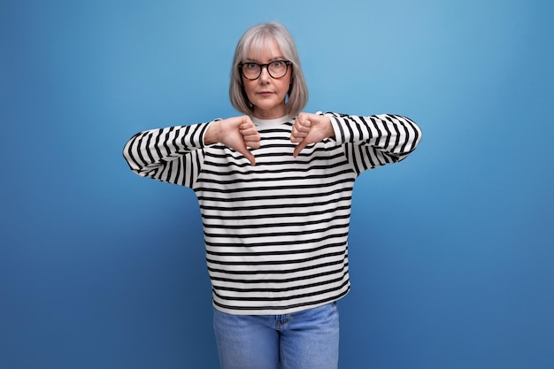 Successful mature woman with gray hair on bright studio background