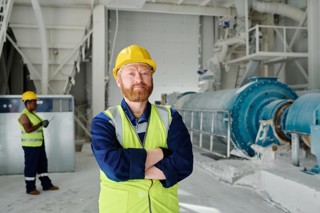 Successful middle aged engineer or worker of marble plant looking at camera