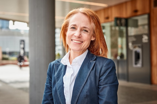 Successful middleaged businesswoman smiling in front of luxury office