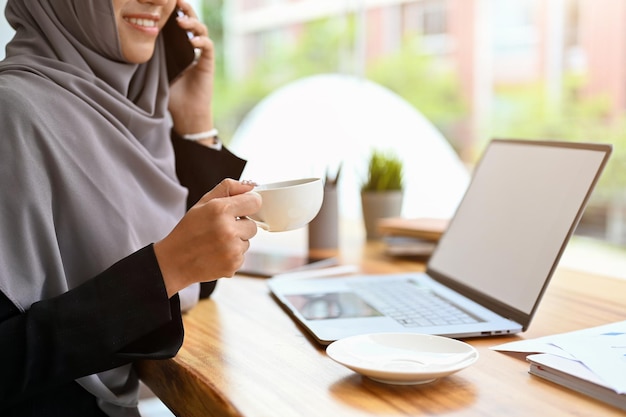 Successful muslim businesswoman wearing hijab on the phone call with business client