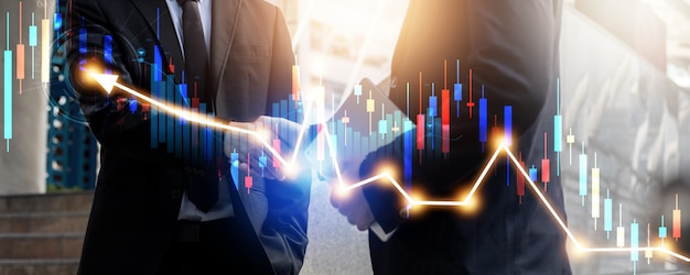 Successful negotiate and achievement concept, two business people shake hand after talk and success in investment deal with financial graph