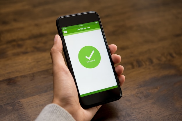 На экране смартфона появляется знак подтверждения успешного онлайн проката автомобиля