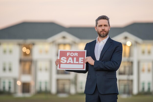 Photo successful real estate agent in suit with sign for sale real estate broker front of new house real e